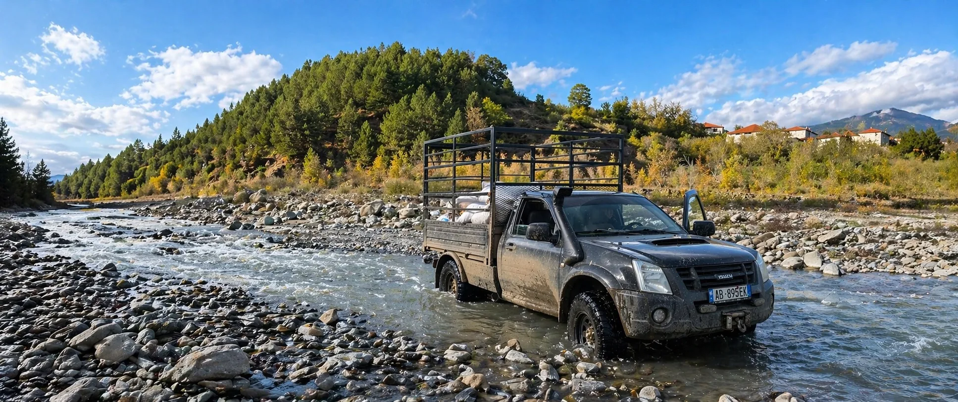 Pick-up BMH chargé traversant une rivière d'altitude lors de la sortie de la vallée d'Elbasan